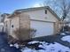 Brick garage with white door and snow on ground at 2147 W 65Th St, Indianapolis, IN 46260