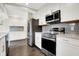 Modern kitchen with white cabinets, stainless steel appliances, and grey backsplash at 3522 Janet Dr, Indianapolis, IN 46218