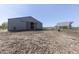 An expansive barn with a sliding door sits beside a large dirt riding arena surrounded by white fencing at 4462 S Morgantown Rd, Greenwood, IN 46143