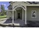House exterior features a covered porch with white columns and a green facade at 7077 E Mulberry St, Gwynneville, IN 46144