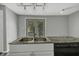 Kitchen features a double sink, granite countertop, and French doors leading outside at 7077 E Mulberry St, Gwynneville, IN 46144