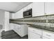 White kitchen with granite countertops and decorative backsplash at 7077 E Mulberry St, Gwynneville, IN 46144
