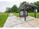 A covered bus stop with seating situated along a walking path and adjacent to a grassy area at 7541 Big Bend Blvd, Camby, IN 46113