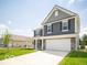 Inviting two-story home featuring gray siding, a covered front porch, green lawn, and an attached garage at 7541 Big Bend Blvd, Camby, IN 46113