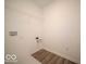 Functional laundry room with hookups, an overhead wire shelf, and light wood-look flooring at 7541 Big Bend Blvd, Camby, IN 46113