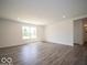 Spacious living area featuring hardwood floors, bright white walls, and a large window at 7541 Big Bend Blvd, Camby, IN 46113