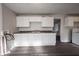 White kitchen cabinets, gray laminate floors, and a double sink at 836 S Tremont St, Indianapolis, IN 46221