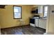 Kitchen with yellow walls, laminate floors, and white cabinets at 901 W Marsh St, Muncie, IN 47303