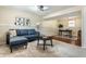 Inviting basement with living area featuring a blue couch and an adjacent office space at 9229 Thrushwood Ln, Indianapolis, IN 46250