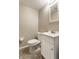 Bathroom with a toilet, sink, and small mirror at 9229 Thrushwood Ln, Indianapolis, IN 46250