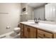 A bathroom featuring wood cabinets, a toilet, mirror, and shower with curtain at 9229 Thrushwood Ln, Indianapolis, IN 46250