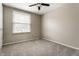 Carpeted bedroom with a window, ceiling fan, and light tan colored walls at 9229 Thrushwood Ln, Indianapolis, IN 46250