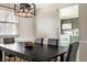 Modern dining room features a contemporary chandelier and a view into an adjacent kitchen space at 9229 Thrushwood Ln, Indianapolis, IN 46250