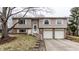 Charming split-level home featuring a two-car garage and a welcoming front entrance with stairs at 9229 Thrushwood Ln, Indianapolis, IN 46250