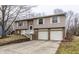 Charming split-level home featuring a two-car garage and a welcoming front entrance with stairs at 9229 Thrushwood Ln, Indianapolis, IN 46250