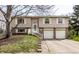 Split-level home with tan siding, white trim, attached two-car garage, and charming front yard at 9229 Thrushwood Ln, Indianapolis, IN 46250