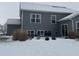 Gray house with back patio, snowy yard, and landscaping at 9426 Orchard Cove Dr, Indianapolis, IN 46239