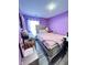 Purple bedroom with a double bed, dresser, and decorative accents at 9519 Meadowlark Dr, Indianapolis, IN 46235