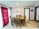 Bright dining room with wood table and six chairs, red curtains, and tiled floor at 9519 Meadowlark Dr, Indianapolis, IN 46235