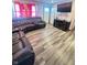 Living room with dark brown leather sectional sofa and wood-look floors at 9519 Meadowlark Dr, Indianapolis, IN 46235