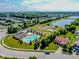 Aerial view of community pool, clubhouse, tennis courts, and playground surrounded by lush landscaping and a serene lake at 10391 Butler Dr, Brownsburg, IN 46112