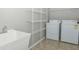 Bright laundry room features washer, dryer, utility sink, and ample shelving at 10391 Butler Dr, Brownsburg, IN 46112