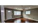 Living room with hardwood floors, white door, and multiple windows at 11 Eastridge Dr, Greenwood, IN 46143
