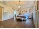 Spacious main bedroom showcasing a tray ceiling, wood floors, and refined gray wainscoting at 11253 Loch Raven Blvd, Fishers, IN 46037