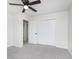 Bright bedroom featuring gray carpet, a ceiling fan, and double sliding doors to closet at 1238 Orchard N Park, Carmel, IN 46280