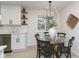 Modern kitchen with white cabinets, stainless steel appliances, and a glass dining table at 1238 Orchard N Park, Carmel, IN 46280