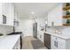 Renovated kitchen boasts white cabinets, stainless steel appliances, and a farmhouse sink at 1238 Orchard N Park, Carmel, IN 46280
