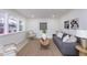 Bright and airy living room with gray sofa, light wood coffee table and large windows at 1238 Orchard N Park, Carmel, IN 46280