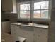 Renovated kitchen with white cabinets, granite countertops, and a farmhouse sink at 12625 Strawtown Ave, Noblesville, IN 46060