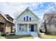 Charming two-story home features a covered front porch with classic architectural details and a freshly painted facade at 2215 Brookside Ave, Indianapolis, IN 46218