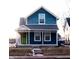 Charming two-story blue house with white trim, front porch, and a lime green door at 2502 N Harding N St, Indianapolis, IN 46208
