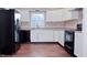Modern kitchen with white cabinets, black appliances, and hardwood floors at 2502 N Harding N St, Indianapolis, IN 46208