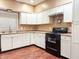 Bright kitchen featuring white cabinets, black appliances, and wood-look floors at 2502 N Harding N St, Indianapolis, IN 46208