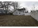 A spacious backyard featuring a mix of grass and foliage, surrounded by a white picket fence at 30 N Muessing St, Indianapolis, IN 46229
