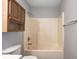 A bathroom showcasing a tub/shower combo, toilet, and wooden storage at 368 Seabreeze Cir, Avon, IN 46123