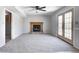 A carpeted living room showcasing a fireplace, ceiling fan, and natural lighting at 368 Seabreeze Cir, Avon, IN 46123