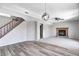 A spacious living room with a fireplace, a ceiling fan, hardwood flooring, and staircase with wooden banister at 368 Seabreeze Cir, Avon, IN 46123