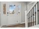 Front entry with white door, wood floors, and black metal railing at 4155 Senour Rd, Indianapolis, IN 46239