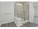 This bathroom features a glass door shower with tile surround and wood-look flooring at 7300 Legends Way, Whitestown, IN 46052