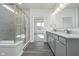 Bathroom with double sinks, quartz countertops, grey cabinets, and a glass shower at 7300 Legends Way, Whitestown, IN 46052
