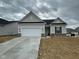 Charming single-story home featuring an attached two-car garage and neutral siding with brick accents at 7300 Legends Way, Whitestown, IN 46052
