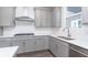 Modern kitchen with gray cabinets, stainless steel appliances, and an island at 7300 Legends Way, Whitestown, IN 46052