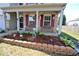 Brick-bordered flower bed and two benches on the covered porch at 833 Palisades Ct, Greenwood, IN 46143