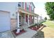 Covered front porch with brick columns, red shutters, and decorative plants at 833 Palisades Ct, Greenwood, IN 46143