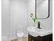 Simple bathroom with a pedestal sink, toilet, and dark vanity at 923 E Pleasant Run Pkwy S Dr, Indianapolis, IN 46203