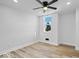 Bright bedroom with ceiling fan, wood-look floors, and large window at 923 E Pleasant Run Pkwy S Dr, Indianapolis, IN 46203